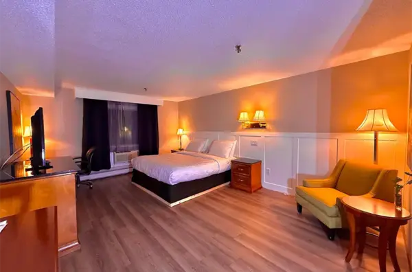 Standard King Room with warm lighting and hardwood floors at Presque Isle Hotel