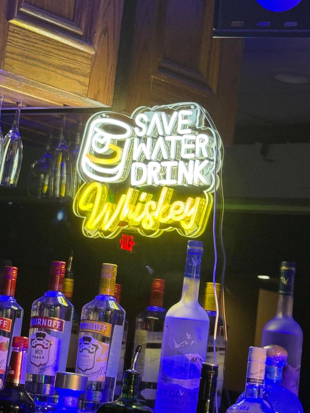 Save Water Drink Whiskey neon sign at the bar